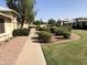 Attractive walkway through landscaped grounds between condos, featuring green grass, bushes and rock at 20215 N Broken Arrow Dr, Sun City West, AZ 85375