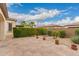 Spacious backyard with a paver patio, desert landscaping, and mature trees, perfect for outdoor activities and relaxation at 229 E Alcatara Ave, Queen Creek, AZ 85140