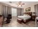 Comfortable bedroom featuring a ceiling fan, tile flooring, and neutral decor at 229 E Alcatara Ave, Queen Creek, AZ 85140