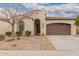 Charming single-story home featuring a desert landscape, paved walkway, and a two-car garage at 229 E Alcatara Ave, Queen Creek, AZ 85140