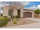 Attractive one-story home boasting a desert landscape, covered entrance, and convenient two-car garage at 229 E Alcatara Ave, Queen Creek, AZ 85140
