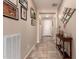 Neutral hallway featuring tile floors, artwork, and a console table with decorative items at 229 E Alcatara Ave, Queen Creek, AZ 85140