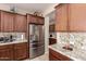 Modern kitchen with stainless steel appliances, granite countertops, and wooden cabinetry at 229 E Alcatara Ave, Queen Creek, AZ 85140
