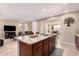Kitchen island with granite countertops, ample counter space and seating, and an adjacent living room at 229 E Alcatara Ave, Queen Creek, AZ 85140
