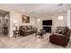 Cozy living area with tile flooring, a large TV, and inviting leather furniture at 229 E Alcatara Ave, Queen Creek, AZ 85140