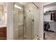 Elegant bathroom shower with glass enclosure, tiled walls, and a convenient built-in seat at 229 E Alcatara Ave, Queen Creek, AZ 85140