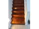 Hardwood staircase featuring a white handrail and natural light, offering a warm welcome at 239 E Betty Elyse Ln, Phoenix, AZ 85022