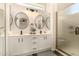 Modern bathroom with double sinks, round mirrors, and a glass-enclosed shower at 24812 S Pleasant Ct, Sun Lakes, AZ 85248