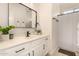 Bright bathroom features a large framed mirror, white cabinets and a black faucet at 24812 S Pleasant Ct, Sun Lakes, AZ 85248