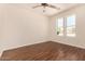 Well-lit bedroom featuring wood-look floors, ceiling fan, and a large window at 24812 S Pleasant Ct, Sun Lakes, AZ 85248