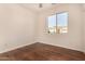 Bedroom featuring wood-look floors, window, and bright white walls at 24812 S Pleasant Ct, Sun Lakes, AZ 85248