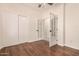 Bedroom features wood-look floors, closet, and glass panel doors at 24812 S Pleasant Ct, Sun Lakes, AZ 85248