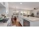 Bright kitchen featuring white cabinetry, farmhouse sink, quartz countertops, and stainless steel appliances at 24812 S Pleasant Ct, Sun Lakes, AZ 85248