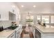 Bright kitchen with white cabinets, stainless steel appliances, a farmhouse sink, and wood floors at 24812 S Pleasant Ct, Sun Lakes, AZ 85248