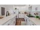 Modern kitchen with white cabinets, stainless appliances, a farmhouse sink, and wood-look flooring at 24812 S Pleasant Ct, Sun Lakes, AZ 85248