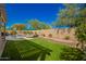 Lush backyard with artificial turf, pool, patio furniture, and privacy wall at 26991 N 97Th Ln, Peoria, AZ 85383