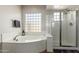 Bright bathroom featuring a tub with tile surround and glass enclosed shower at 26991 N 97Th Ln, Peoria, AZ 85383