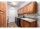 Well-equipped laundry room with wood cabinets, washer, dryer, and a utility sink at 26991 N 97Th Ln, Peoria, AZ 85383
