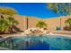 Beautiful pool with rock waterfall feature and lush tropical landscaping creates a serene backyard retreat at 26991 N 97Th Ln, Peoria, AZ 85383
