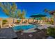 Inviting backyard pool area with desert landscaping, blue accents, and resort-style umbrellas for shade at 26991 N 97Th Ln, Peoria, AZ 85383