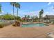 Community pool area featuring a waterfall, palm trees, a cabana, and ample lounging space at 2929 W Yorkshire Dr # 2013, Phoenix, AZ 85027