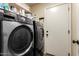 Laundry room featuring black washer and dryer and white door at 30411 N 42Nd Pl, Cave Creek, AZ 85331