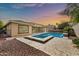 Beautiful backyard featuring a sparkling pool with attached hot tub, travertine tile patio and ample space for entertaining at 3220 N 136Th Dr, Avondale, AZ 85392