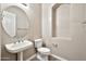 Stylish powder room with a pedestal sink and oval mirror providing a clean and elegant space for guests at 3220 N 136Th Dr, Avondale, AZ 85392