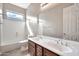 Bathroom featuring double vanity, a combination shower and tub, and large window at 3220 N 136Th Dr, Avondale, AZ 85392