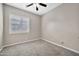 Bright bedroom featuring neutral carpet, a ceiling fan, and a window with plantation shutters at 3220 N 136Th Dr, Avondale, AZ 85392