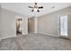 Spacious carpeted bedroom boasts a ceiling fan and a door leading to the outside at 3220 N 136Th Dr, Avondale, AZ 85392