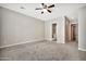 Large carpeted bedroom featuring neutral colors, a ceiling fan and bathroom access at 3220 N 136Th Dr, Avondale, AZ 85392