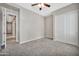 Bright bedroom featuring neutral carpet, a ceiling fan, and a closet with sliding doors at 3220 N 136Th Dr, Avondale, AZ 85392