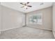 Bright carpeted bedroom with a ceiling fan, shuttered windows and a door to the patio at 3220 N 136Th Dr, Avondale, AZ 85392