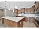 Modern kitchen featuring custom cabinets, stainless steel appliances, a large island, and a stylish backsplash at 3220 N 136Th Dr, Avondale, AZ 85392