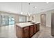 Open kitchen boasts a central island with sink and stainless steel appliances, seamlessly connecting to the inviting living spaces at 3220 N 136Th Dr, Avondale, AZ 85392
