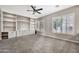Cozy living room with plush carpet, built-in shelving, and plantation shutters creating a warm and inviting atmosphere at 3220 N 136Th Dr, Avondale, AZ 85392