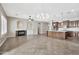 Spacious open-concept living room, dining, and kitchen area features a fireplace, tile floors, and modern lighting at 3220 N 136Th Dr, Avondale, AZ 85392