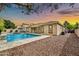 Backyard oasis with a pristine pool, covered patio, desert landscaping, and a tranquil setting for outdoor relaxation at 3220 N 136Th Dr, Avondale, AZ 85392