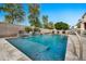 Beautiful swimming pool with a baja step and spa featuring a lovely waterfall creating an oasis for relaxation at 3220 N 136Th Dr, Avondale, AZ 85392