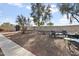 Open backyard with mature trees, a shed, swing set, and stone landscaping, designed for enjoyment at 36765 W Mediterranean Way, Maricopa, AZ 85138