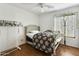 Comfortable bedroom featuring a ceiling fan, hardwood floors, and a window with decorative ivy at 36765 W Mediterranean Way, Maricopa, AZ 85138