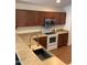 Functional kitchen with stainless steel microwave, electric range, and spacious neutral countertops at 36765 W Mediterranean Way, Maricopa, AZ 85138