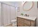 Updated bathroom with a single sink vanity, round mirror, and a shower with curtain at 3925 W Hackamore Dr, Phoenix, AZ 85083