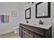 Modern bathroom features a double vanity with rustic wood cabinetry and black fixtures at 3925 W Hackamore Dr, Phoenix, AZ 85083