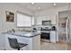 Bright kitchen with white cabinetry, granite countertops, stainless steel appliances and bar seating at 3925 W Hackamore Dr, Phoenix, AZ 85083