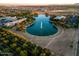 Scenic aerial view showcasing a tranquil lake with a fountain, surrounded by lush landscaping and a residential community at 4084 E Rawhide St, Gilbert, AZ 85296