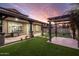 Beautiful backyard with a covered patio, lush green lawn, pergola with an outdoor seating area, and manicured landscaping at 4084 E Rawhide St, Gilbert, AZ 85296