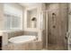 Modern bathroom featuring a separate shower, soaking tub, and tiled walls at 4084 E Rawhide St, Gilbert, AZ 85296