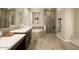 Well-lit bathroom with double vanity, soaking tub, glass enclosed shower, and tiled walls at 4084 E Rawhide St, Gilbert, AZ 85296